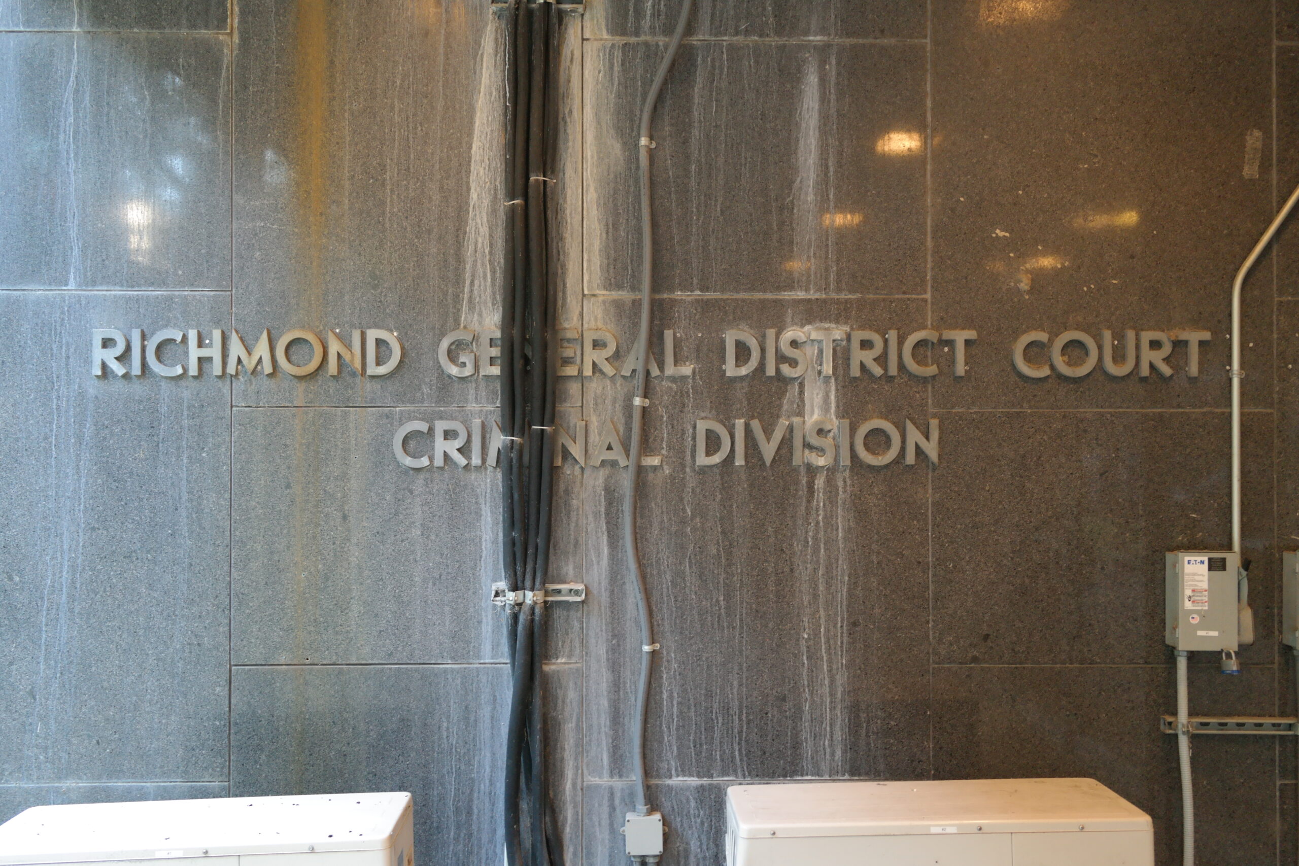 Sign on the wall covered up by HVAC lines